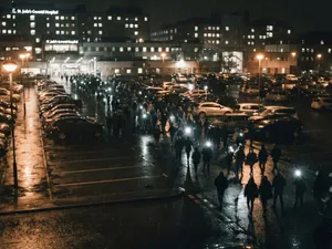 Halloween Kills: sjukhusparkering i regn nattetid där en folkmassa med ficklampor rör sig mellan bilarna