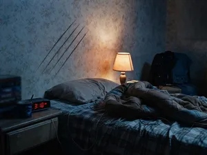 Terror på Elm Street i ordning: tonårsrum på natten med fyra repor i tapeten ovanför sängen och en tänd sänglampa